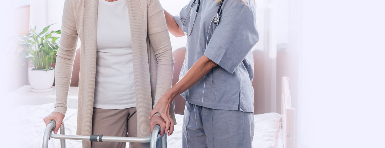 nurse and senior woman with walker smiling each other in hospital room